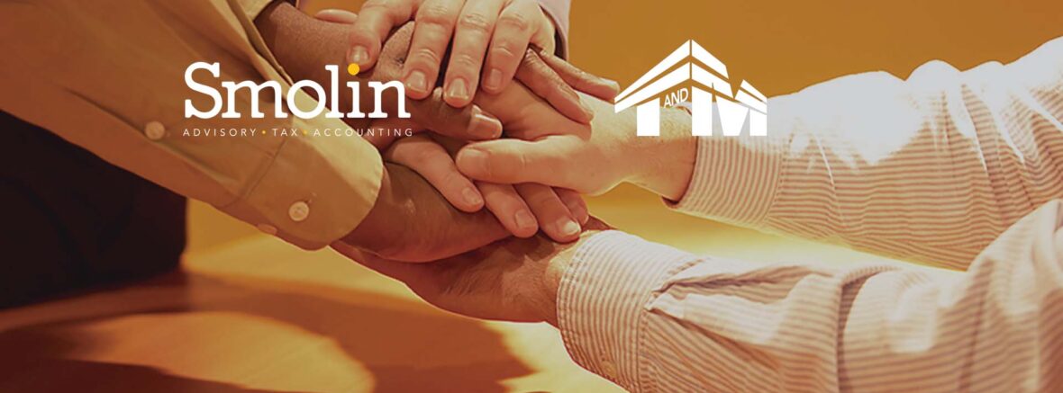 a group of businesspeople holding hands in support. Logos over the picture for Smolin Advisory, Tax, and Accounting and for T & M